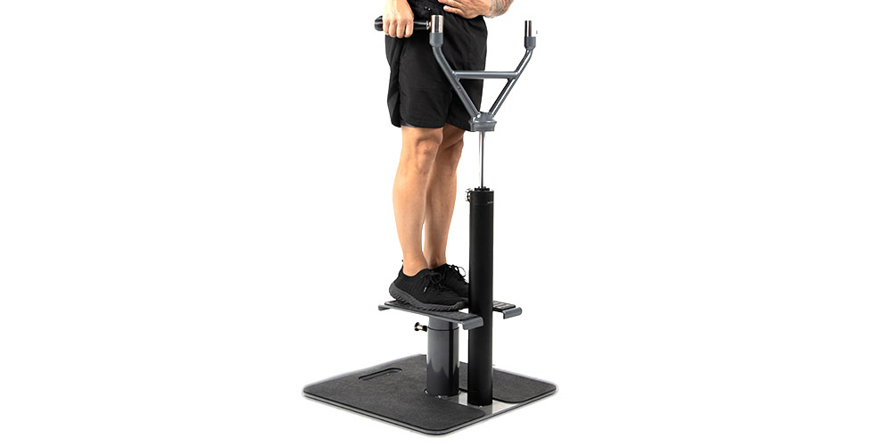 A person standing on a home gym and trainer. 